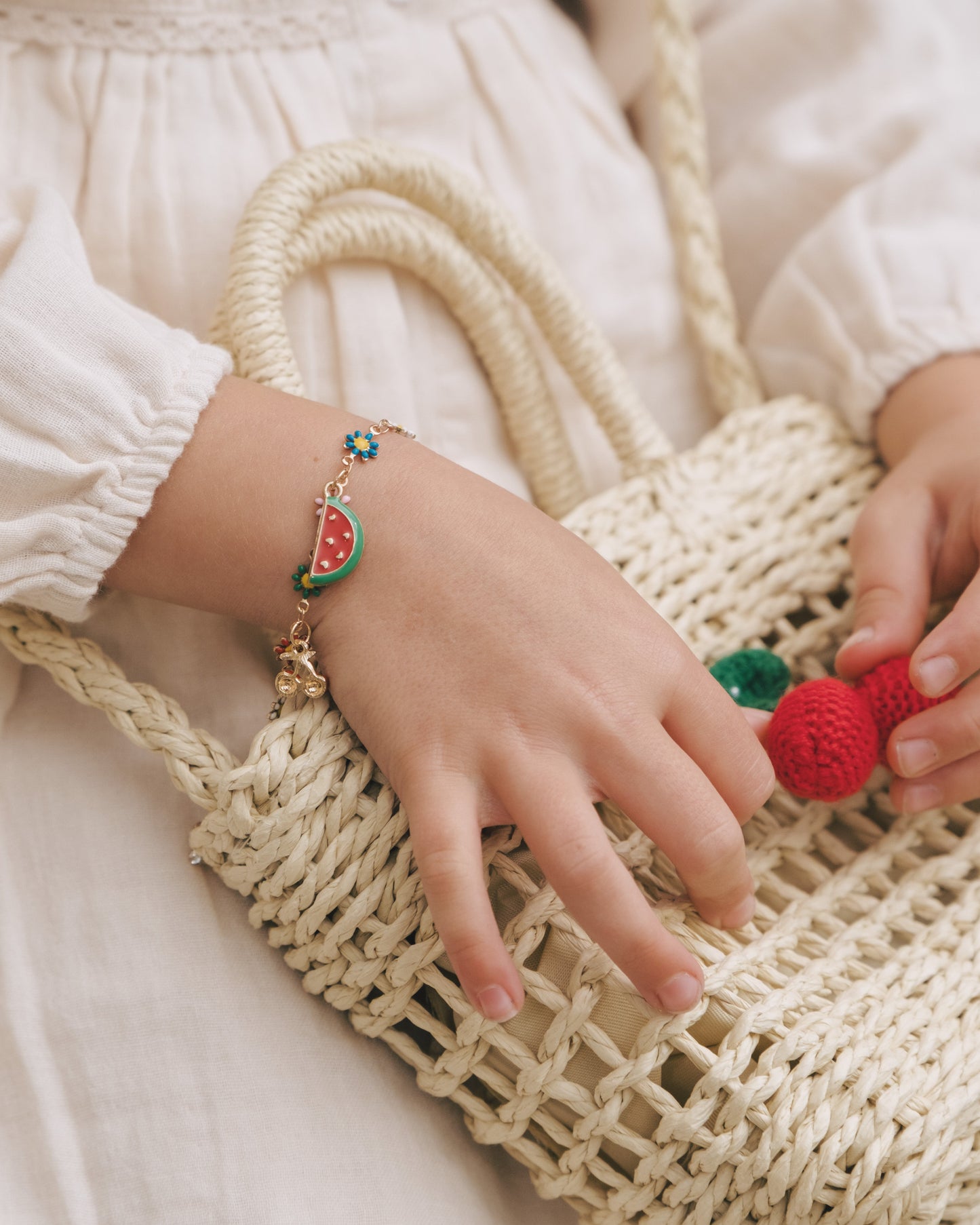 Young girl wearing a handcrafted woodland treasure bracelet with vibrant nature-themed charms