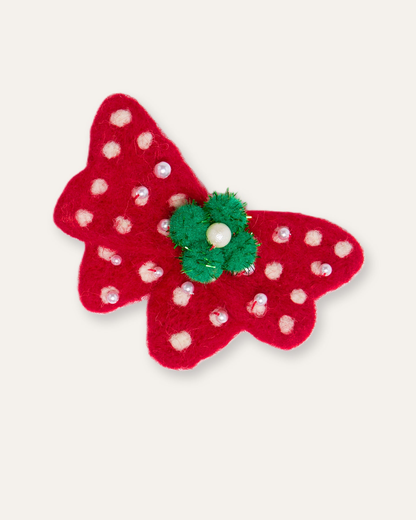 Festive red holiday bow clip with white snowflake dots and delicate pearl accents
