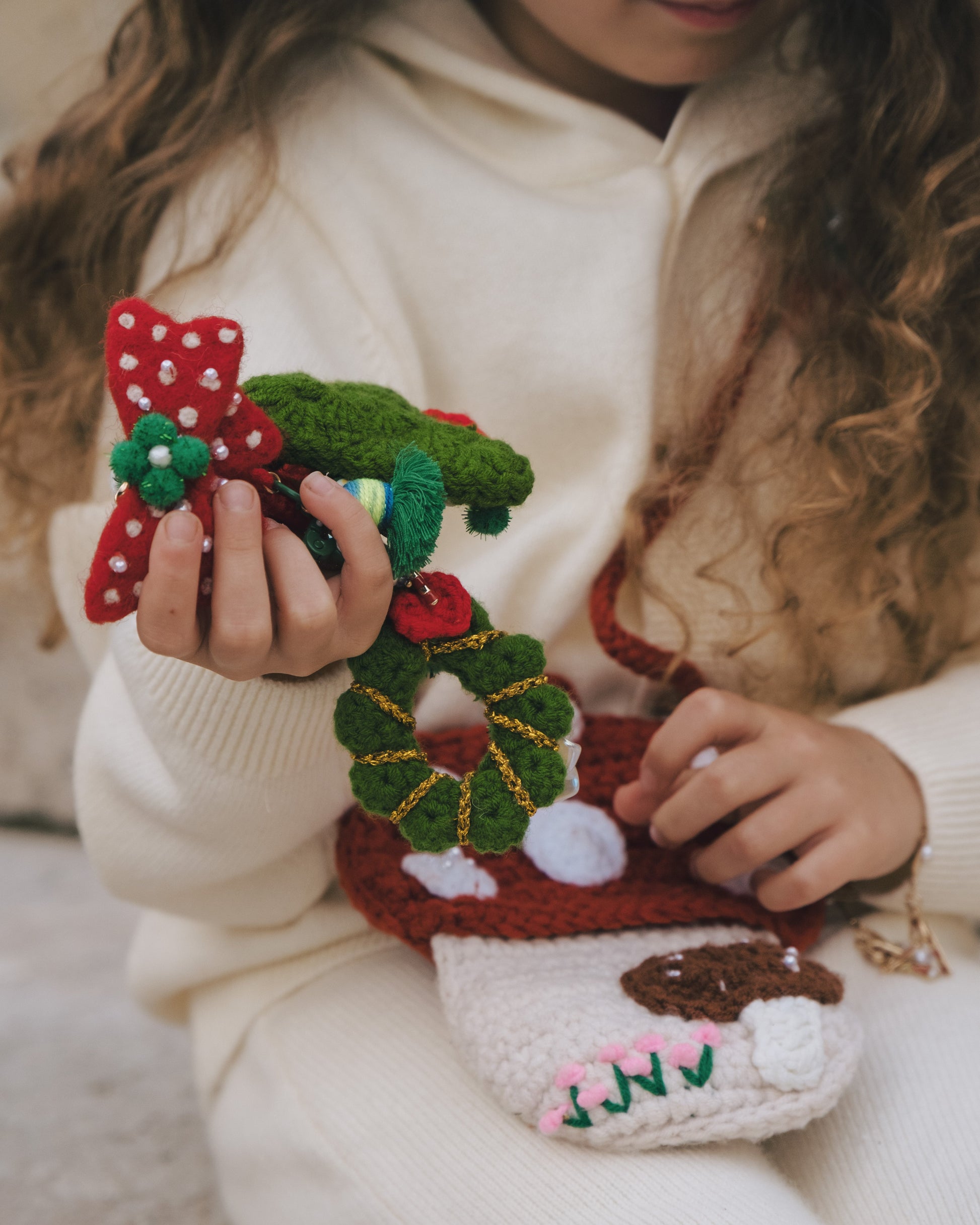 close-up of green pom-pom center and hand-applied pearls on a Christmas bow clip