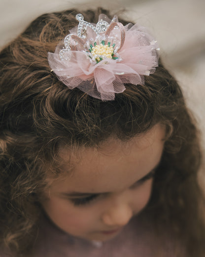 Detailed view of hand-set crystals and layered pink fabric on a princess hair accessory